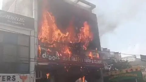 Incendio devastador en un edificio de tres niveles en Lucknow, India, con llamas intensas que consumen la fachada del instituto educativo.
