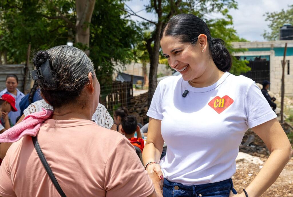 Estefanía Mercado sonríe mientras conversa con una mujer durante la jornada "Tu identidad sin tanto choro" en la colonia Nueva Esperanza.