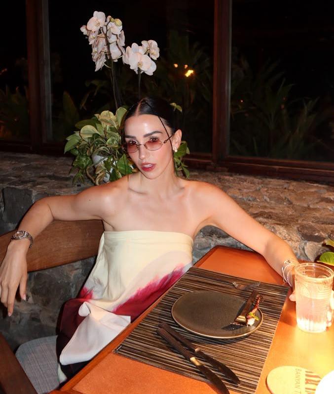 Estíbaliz Badiola posando en un restaurante, luciendo un vestido sin mangas y gafas de sol, mientras se prepara para su carrera musical.