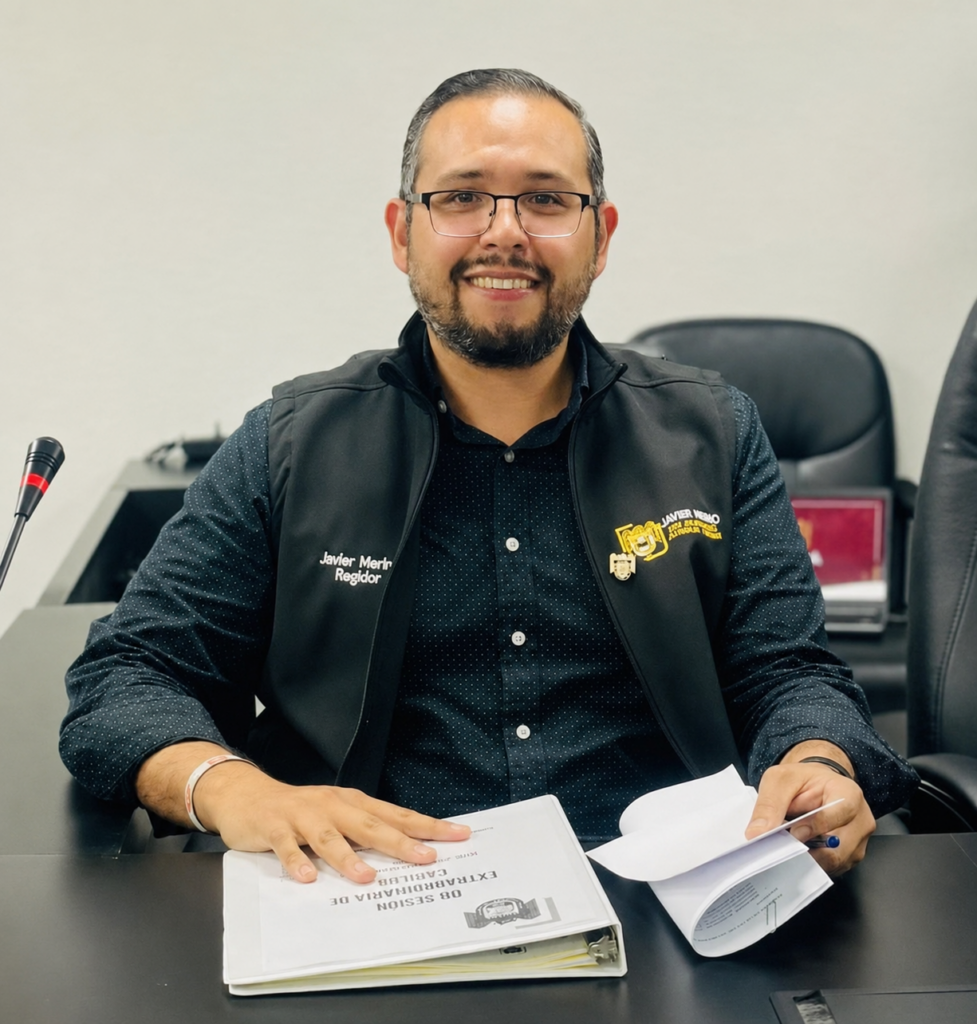 Javier Merino Cuevas, Secretario General, sentado en una mesa con documentos, discutiendo políticas laborales en Tijuana, Baja California.