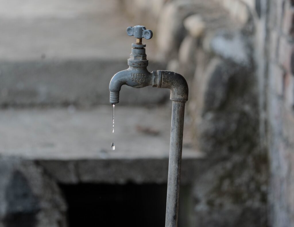 Grifo de agua oxidado goteando, simbolizando la crisis del suministro de agua en Iztacalco, CDMX, por trabajos de mantenimiento.