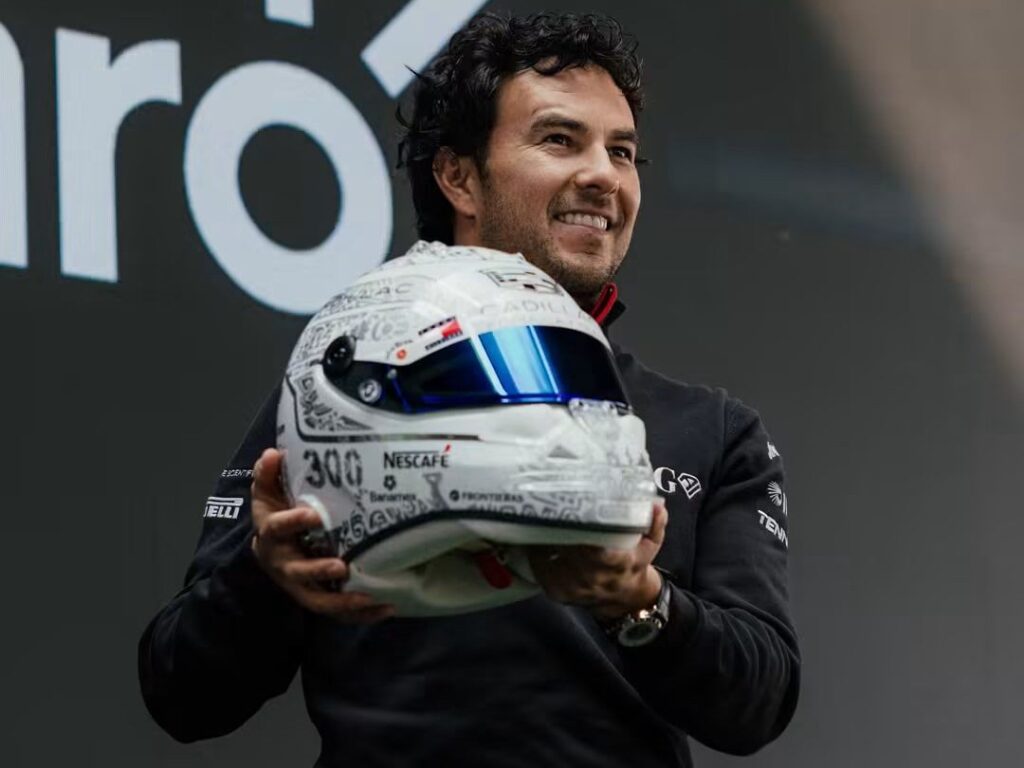 Sergio Checo Pérez sostiene su casco especial con símbolos mexicanos y el número 300, durante la presentación en Plaza Carso, CDMX.